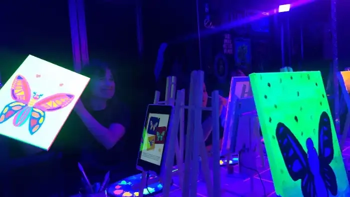 Easels with canvases painted in fluorescent colours under ultraviolet light during a Tinto y Tinta session in Madrid