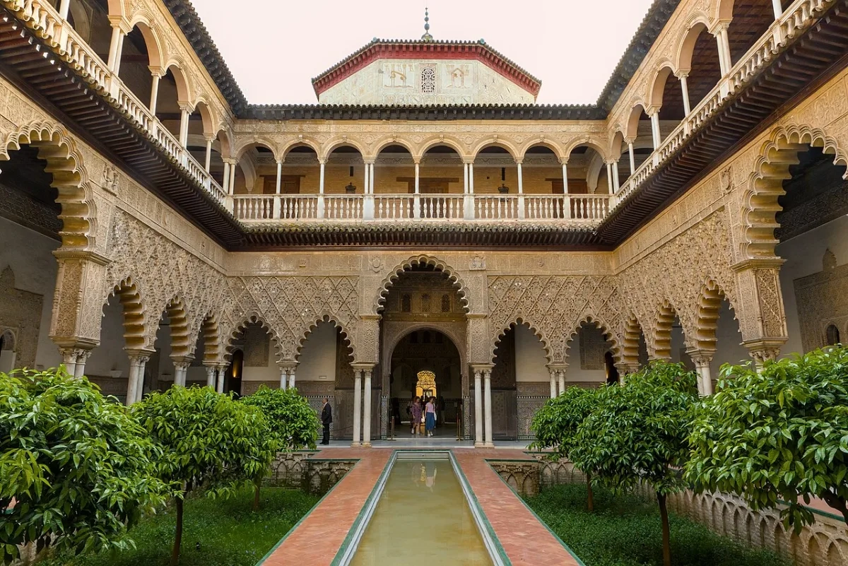 Patio de las Doncellas del Real Alcázar de Sevilla, con sus arcos de yesería y el estanque central