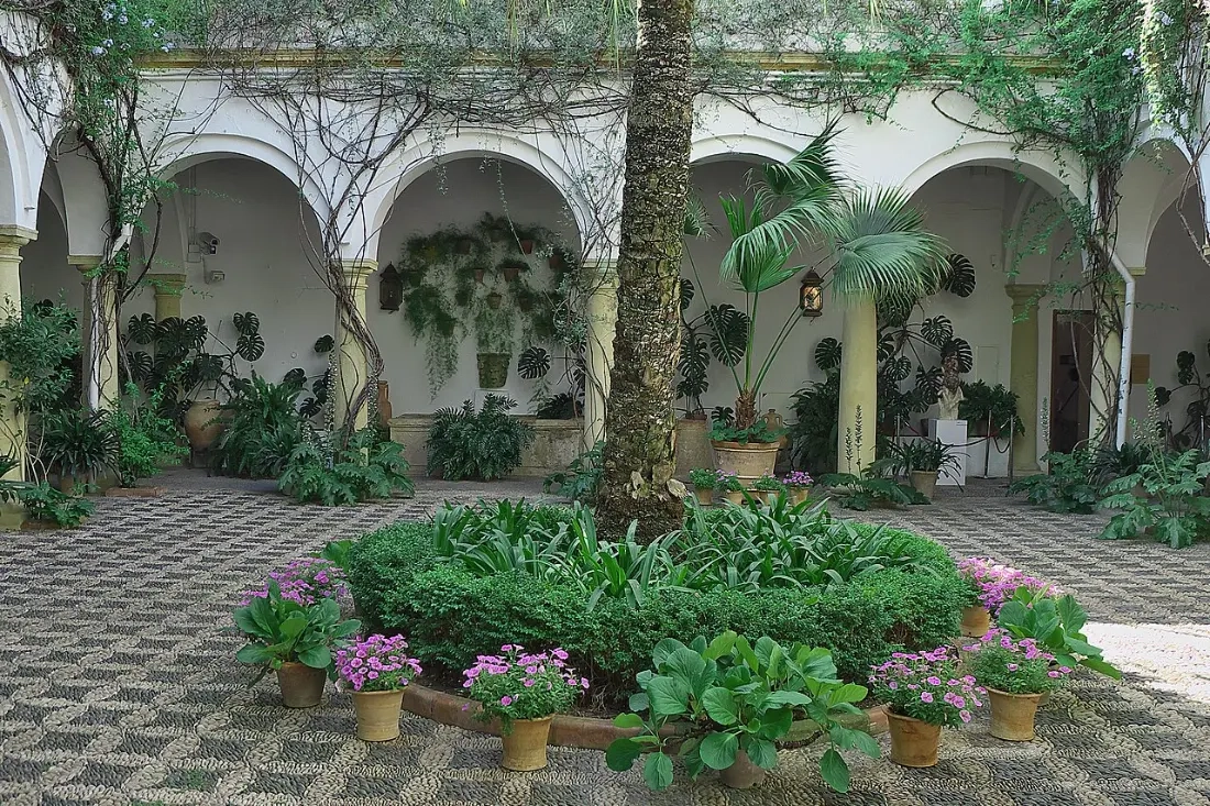 Patio de Recibo del Palacio de Viana de Córdoba, con columnas, suelo empedrado y macetas en las paredes