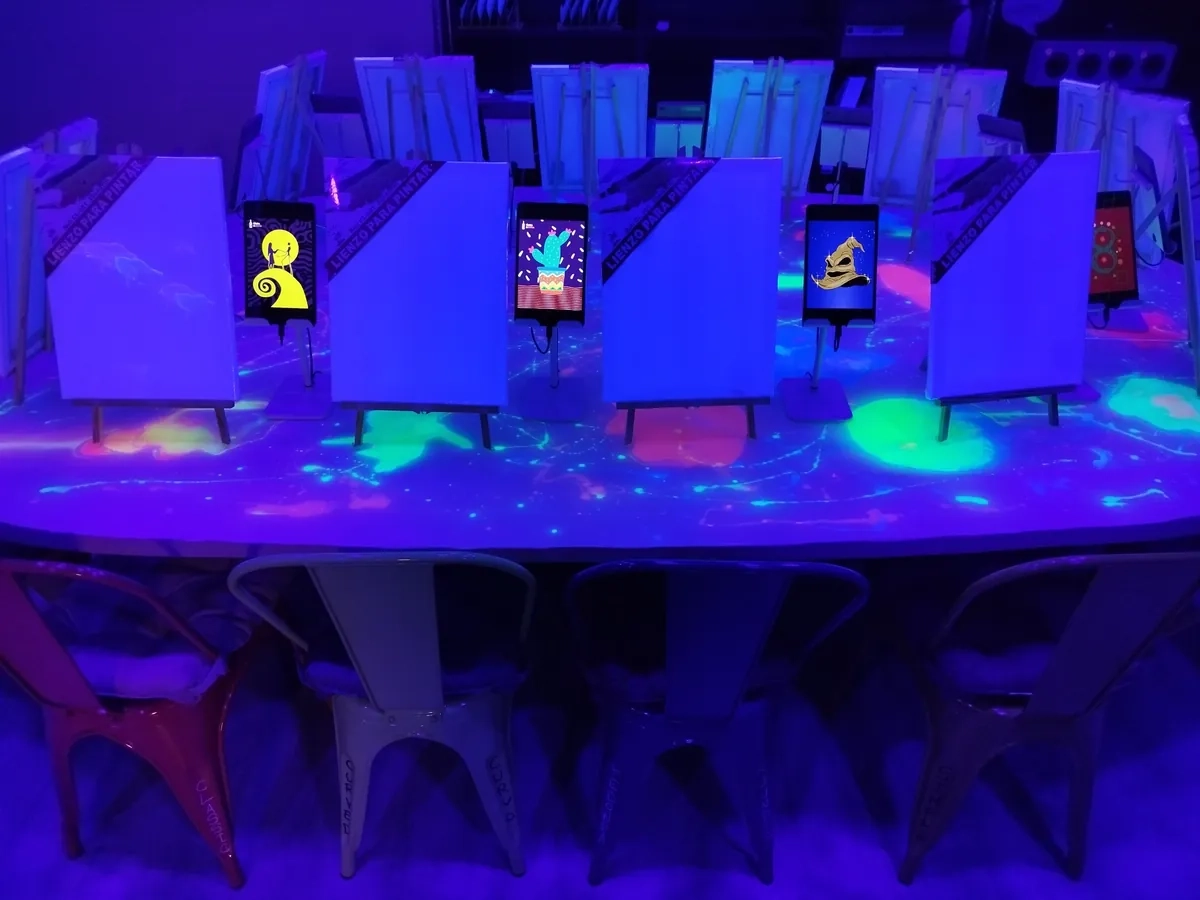 Lienzos iluminados con luz negra en Tinto y Tinta Málaga, una de las experiencias en Málaga para regalar