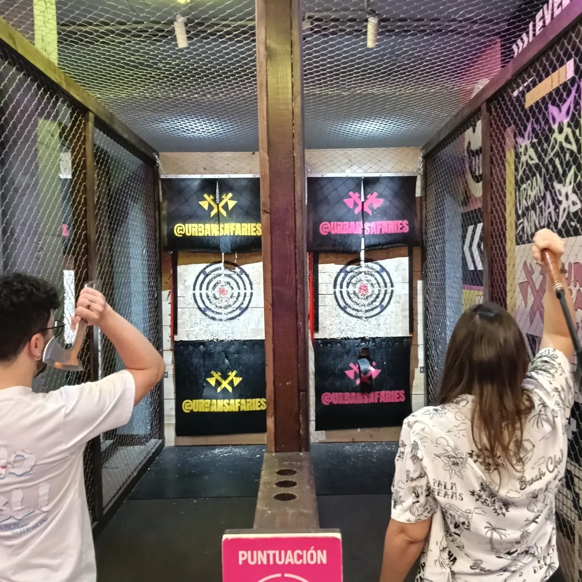 Dos personas lanzando hachas en las calles de tiro de Urban Safari Málaga