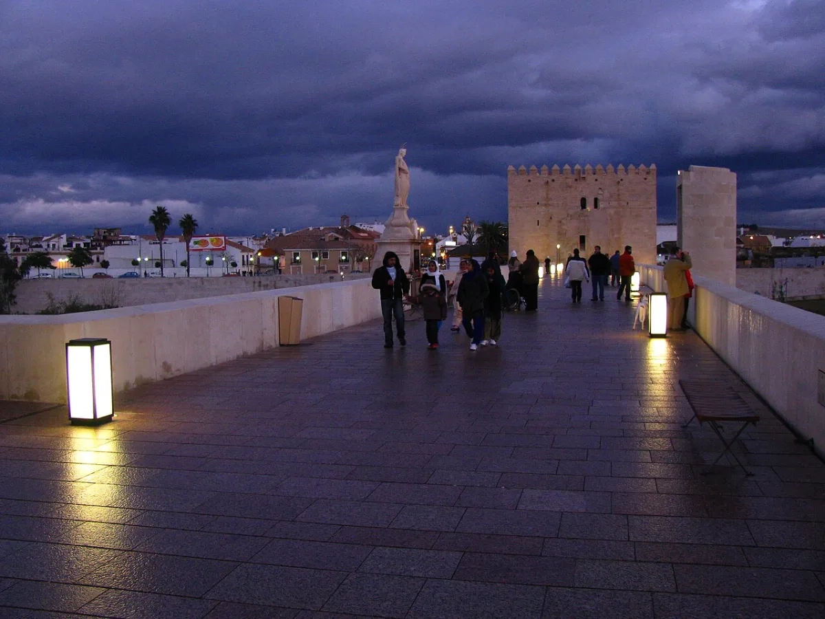 El Puente Romano de Córdoba iluminado de noche, junto a la zona de copas de la Ribera