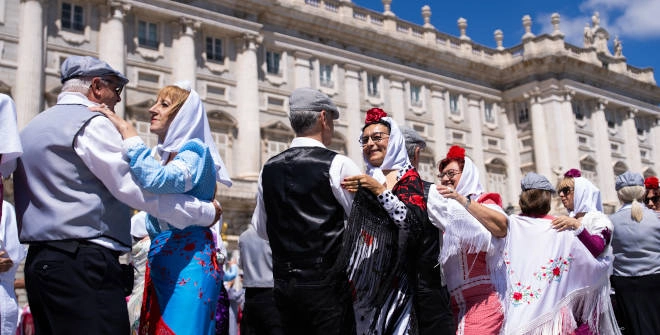 Chulapos y chulapas bailando un chotis en el Palacio Real de Madrid por las fiestas de San Isidro 2026.