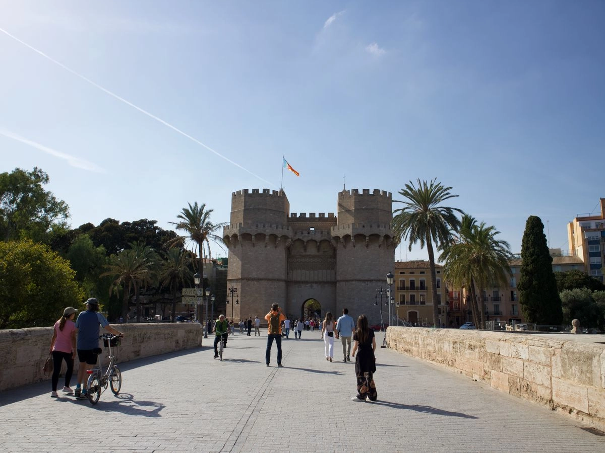 Las Torres de Serranos de Valencia vistas desde el puente, con visitantes en la entrada