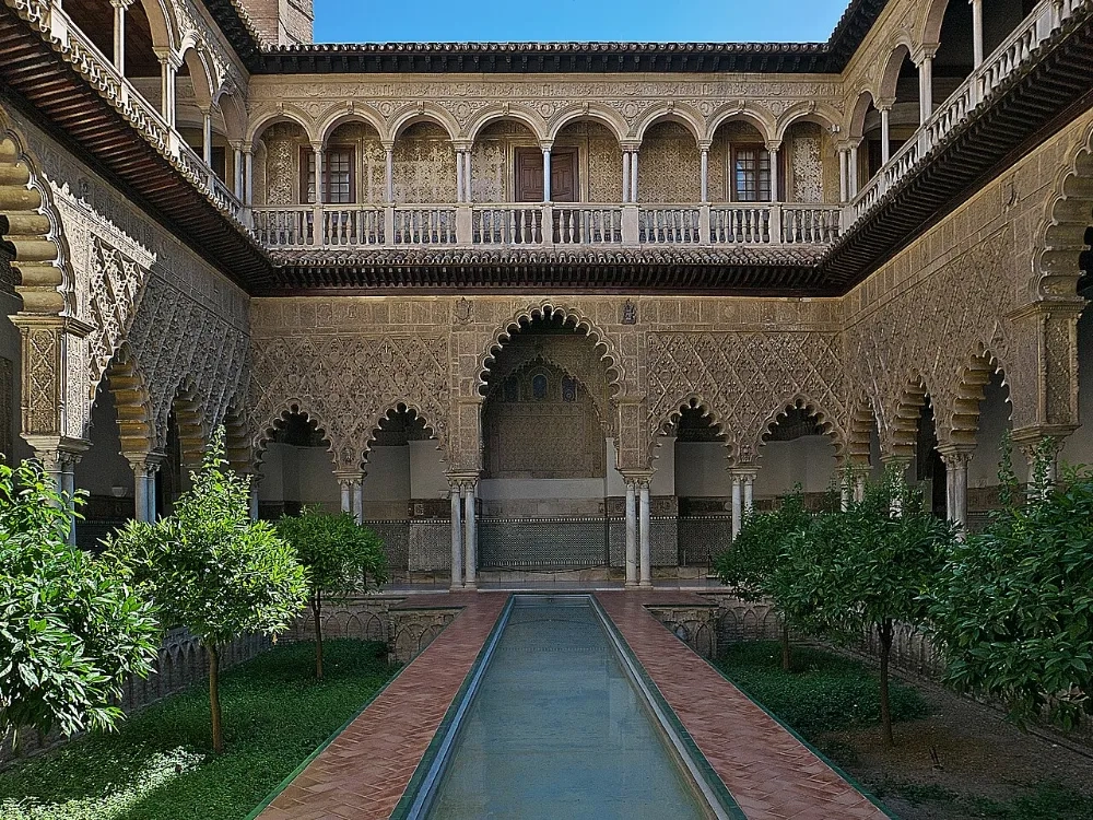 Patio de las Doncellas del Real Alcázar de Sevilla, con su arquería mudéjar y el estanque central