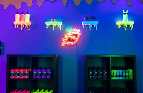 Pared de neones y botes de pintura fluorescente en Tinto y Tinta Alicante